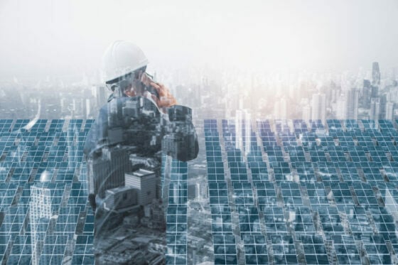Double-exposure-construction-worker-city-and-solar-panels-scaled-e1656430914455